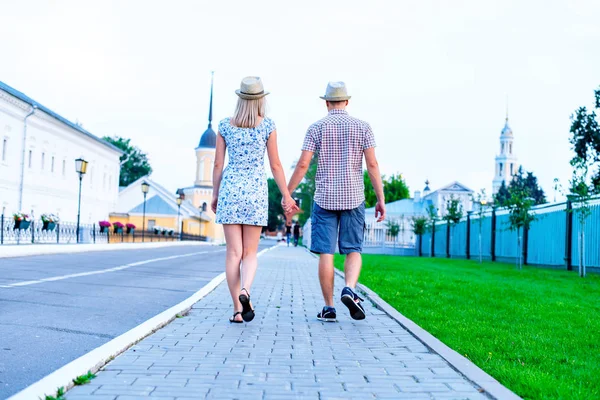 Erkek ve kadın vardır el ele tutuşarak taş kaldırımda yaz şehirde, olay genç aile kavramı yeni evliler karmaşık ilişki. Romantik bir yaşam tarzı. Açık havada.