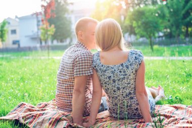 Mutlu bir genç modern çift bir ekose bir parkın içinde oturur, aşk, heart-to-heart nereli, mutlu bir aile, genç bir yaşam tarzı, yeni bir aile Bildirgesi