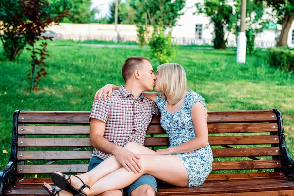 Jeune couple moderne embrassant dans le parc, en été dans la ville, horizontal, famille dans la nature reposant, concept de famille heureuse, mode de vie. Ils vont regarder dans les yeux. Une déclaration d'amour. Embrasse — Photo