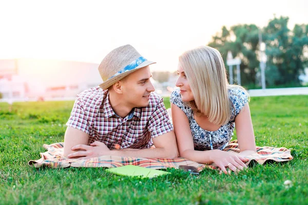 Ein glückliches junges modernes Paar in einem Park auf karierten Lügen, Liebeserklärung, Gespräch über Liebe, eine glückliche Familie, Teenager-Lebensstil, eine neue Familie — Stockfoto