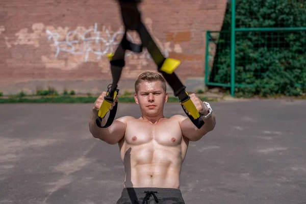 Mannelijke atleet close-up, treinen natuur in stad, zomer opleiding lussen opleiding, voel je je kracht en evenwicht, motivatie, gebruinde huid shorts. Oefenen borstspieren. Een zonnige dag. — Stockfoto