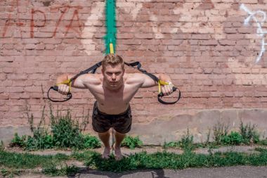 Erkek atlet mükemmel bir eğitim eğitim eğitim döngüler, yaz aylarında doğa şehir sıkma hissediyorum güç ve denge, motivasyon, tabaklanmış deri. Göğüs kasları egzersiz. Güneşli bir gün.