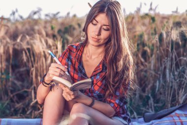 Bir alanda güzel mutlu esmer kız gömlek. Kavram yeni fikirler, not defterinde yazılı. Hava üzerinde bekletin. Öğrenci kişisel bir günlük fikir yürüten.