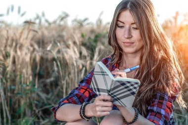 Güzel kız öğrenci alan. Gazeteci. Kavram yeni fikirler, doğada yaz. Elinde o defter, uzun saç yazıyor. Zeki fikirler. Yaratıcılık ilham. Günlük okur.
