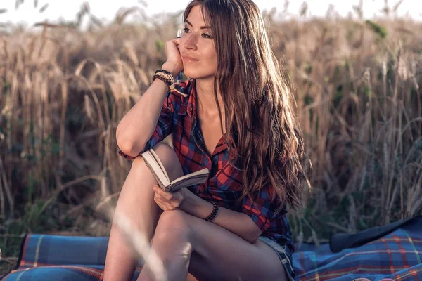 Güzel esmer kız alanında gömlek şort. Kavram yeni fikirler, Düşler ve fantasies. Doğada taze yaz aylarında mutlu. Onun el bir dizüstü bilgisayar, bir alandaki uzun saç.