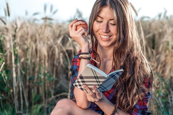Güzel kız öğrenci alan. Elinde bir elma olduğunu. Yeni fikirler, gülümseyen, doğa üzerinde yaz aylarında kavramı. Bir dizüstü bilgisayar, uzun saç el. Zeki fikirler. Yaratıcılık ilham. Günlük okur.
