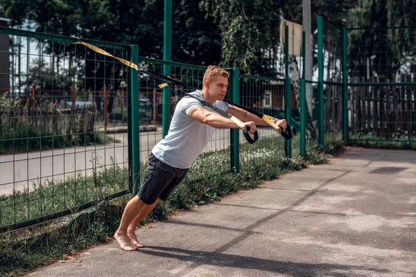 Bir erkek atlet açık hava döngüler, çit, şınav devreye girer. Yaz aylarında, şort ve beyaz bir tişört. Y sağlıklı yaşam tarzı