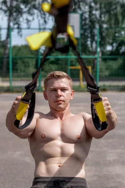 Hombre atleta primer plano, entrena la naturaleza en la ciudad, entrenamiento de verano bucles de entrenamiento, Siente tu fuerza y equilibrio, motivación, piel bronceada. Ejercicio de los músculos pectorales —  Fotos de Stock