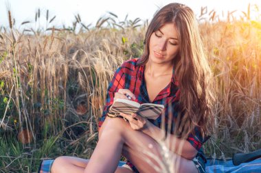 Buğday doğa, güzel esmer saçları rahatlatıcı bir alan gömlekli oturan kız. O gelecekten bir defter pnans yazıyor. Dersten sonra bir öğrenci. Kavram notları görüşme için derslerdir.