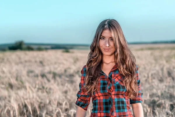 Mooi meisje in brunette veld met lange donkerbruine haren, ontspannen in de natuur, close-up. — Stockfoto