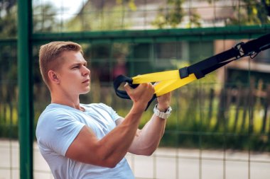 Sporcunun silah pazı kas kayışlar. Erkek atlet, menteşeler, fiziksel egzersizleri yapıyor meşgul. Temiz havada egzersiz. Sağlıklı bir yaşam tarzı kavramı.