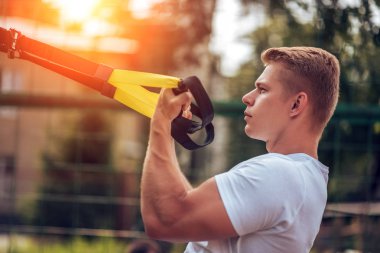 Atlet kol kasları pazı triceps kaslarının kayışlar. Erkek atlet, menteşeler, arka close-up nişanlı. Yaz aylarında bir çit var. Sağlıklı bir yaşam tarzı kavramı. Güneş'in Parlatıcı.