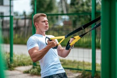 Atlet kol kasları pazı triceps kaslarının kayışlar. Erkek atlet, menteşeler, yakın çekim göğüsler nişanlı. Yaz aylarında zemin sporda. Temiz hava egzersiz. Sağlıklı bir yaşam tarzı kavramı.