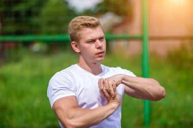 Takım kasları uzanıyor. Koç erkek tişört yaz niteliğine, şehirde ısınma yapar. Doğada atlet. Sağlıklı bir yaşam tarzı kavramı. Taze egzersiz 