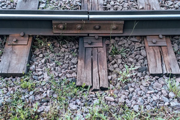 İle ot çakıl. Orada şehirde eski uyuyanlar bir tramvay hattı var. Doğada, ıslak bir ahşap tahta. Metal raylar kaplin.