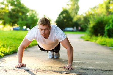 Siyah şort ve beyaz bir T-shirt erkek atlet şınav yapar. Sağlıklı bir yaşam tarzı kavramı. Güç ve motivasyon