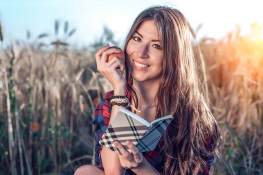 Güzel kız öğrenci alan. Elinde bir elma olduğunu. Yeni fikirler, gülümseyen, doğa üzerinde yaz aylarında kavramı. Bir dizüstü bilgisayar, uzun saç el. Zeki fikirler. Yaratıcılık ilham. Günlük okur.