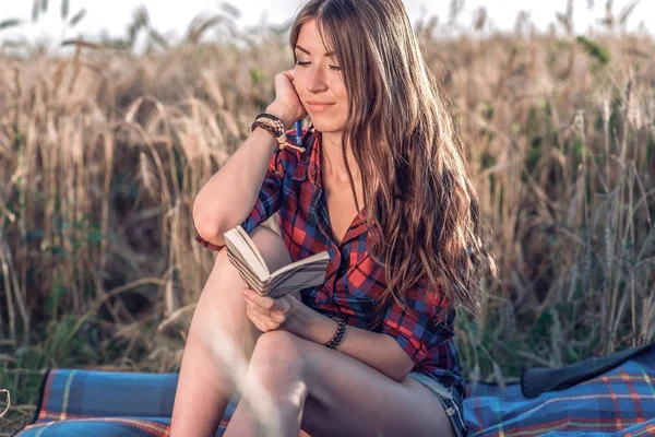 Mooie gelukkig brunette meisje veld is in slaap vallen, shirt. Concept nieuwe ideeën, schrijven in notitieblok. Denkt over aard. Een leerling leest een dagboek van een notitie. — Stockfoto