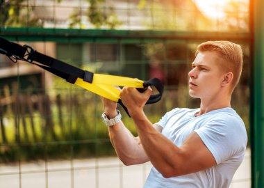 Bir erkek atlet açık havada spor için geçerlidir. Kaslı kolları. Sarışın beyaz bir tişört. Vücut yaşam tarzı