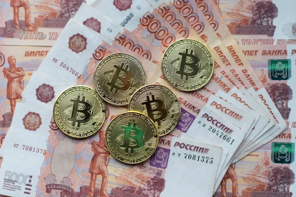 Monedas bitcoin, mentira en un billete de 5000 mil rublos. Los billetes se distribuyen en la mesa en un orden gratuito . —  Fotos de Stock