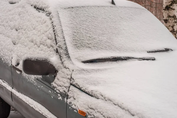 Auto je pokryta sněhem na parkovišti, špinavé auto do sněhu, v zimě na parkovišti. — Stock fotografie