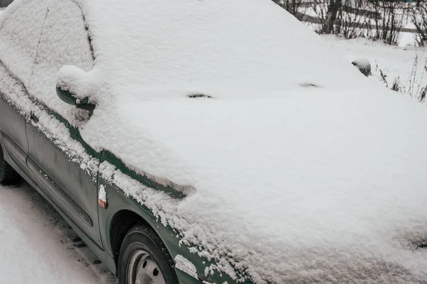 Auto je pokryta sněhem na parkovišti, špinavé auto do sněhu, v zimě na parkovišti. — Stock fotografie