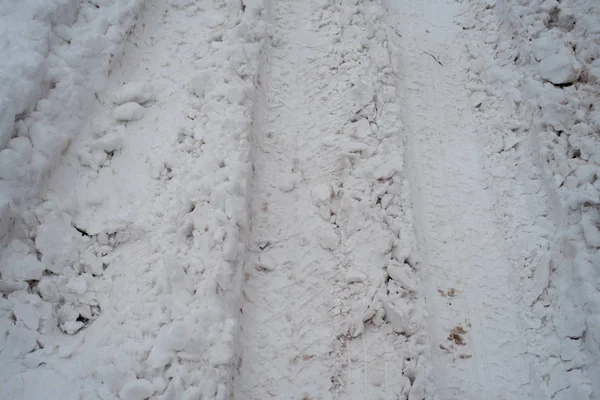 Traces de roues sur neige blanche. Beaucoup d'empreintes des roues des voitures. Vente de neige en hiver d'un grand nombre de camions . — Photo