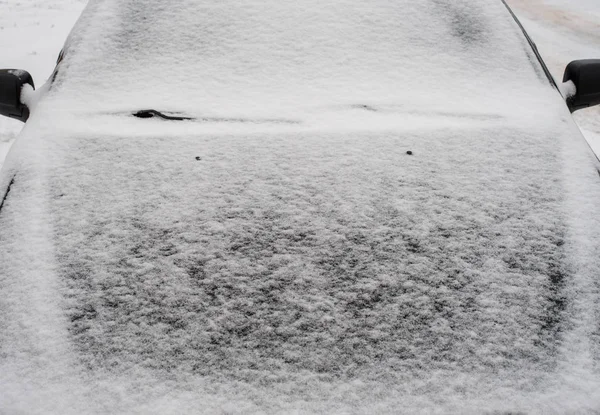 V zimě je zaparkované auto. Bílé zasněžené kapotu, sklo pokryté sněhem z okna auta. — Stock fotografie