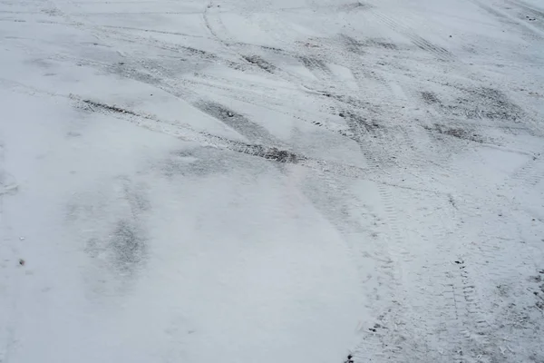 Зимой следы машин от колес в снегу в городе, на перекрестке. Белый и грязный снег . — стоковое фото