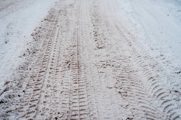Снежная дорога в городе зимой, следы машин от колес . — стоковое фото