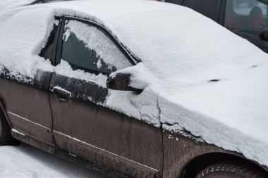 Beyaz bir rüzgârla oluşan kar yığını ile kaplı araç karda,.