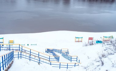 Karla kaplı Bahçesi kışın nehir kıyısında. Nehre nehir ridge yanındaki karlı tepeleri.
