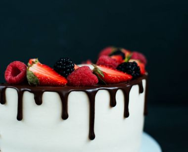 Yakın çekim kek çilek ahududu ile siyah arka plan üzerine. Çikolata lezzetleri ile diyet beyaz krema.