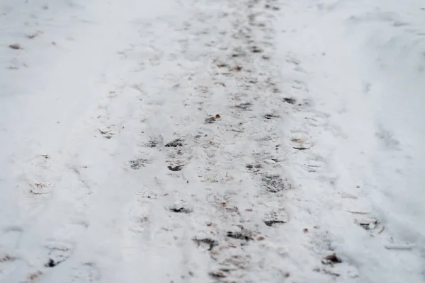 冬の雪の上の交差点の歩行者の足跡。多くの足の印刷、都市の道路で冬のハイキングの路上. — ストック写真