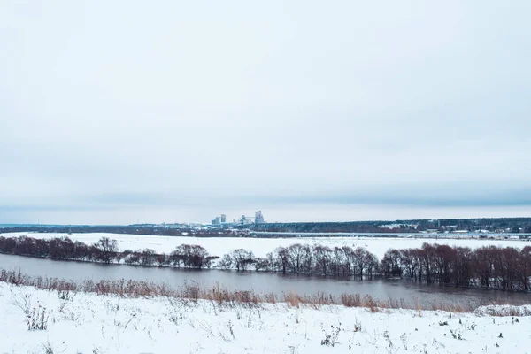 Pemandangan musim dingin, sungai melawan hutan pohon yang tertutup salju. Latar belakang musim dingin yang indah. White Hills jarak . — Stok Foto