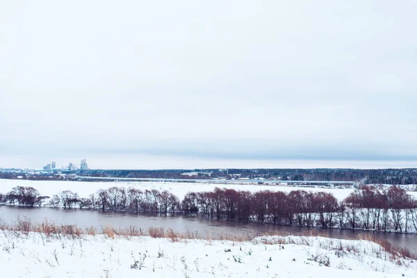 Зимний пейзаж, река против леса заснеженных деревьев. Зимний фон в природе. Белые холмы на расстоянии . — стоковое фото