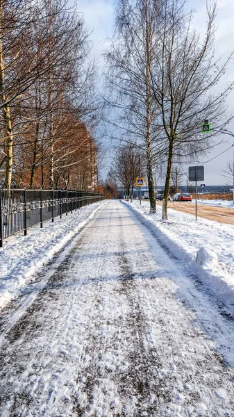 Il sentiero viene ripulito dalla neve, in inverno la neve viene ripulita sull'asfalto in città. Una strada libera per i passanti . — Foto Stock