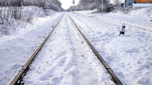 Il sentiero tra i dormienti in con una beatitudine. Dorme dal treno, treno elettrico in città in inverno. Sono coperti di neve da una tempesta. La strada che va in lontananza . — Foto Stock