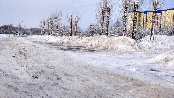 Очистка улицы от снега зимой в городе на обочине . — стоковое фото