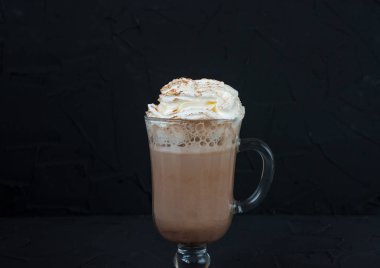 Cam kupa kakao ve siyah arka plan üzerine krema ile.