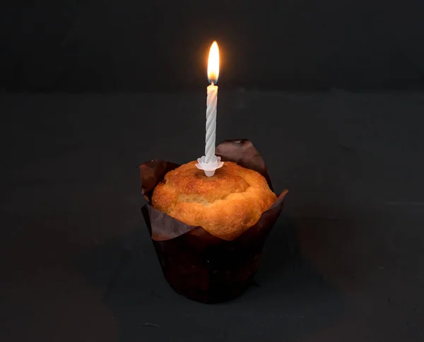 Un pastel con una vela sobre fondo negro. La vela del luto arde . —  Fotos de Stock