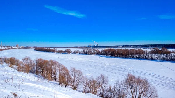 Musim dingin di sungai beku diselimuti salju. Pemandangan danau yang indah dalam es. Langit biru cerah dengan awan . — Stok Foto