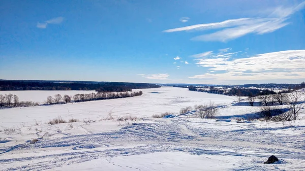 Sungai beku di musim dingin tertutup salju. Pemandangan danau yang indah dalam es. Langit biru cerah dengan awan . — Stok Foto