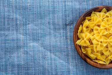 Farfalle makarna makarna örme mavi ahşap kase arka tarafı ile dokulu. Top yakın çekim. Metin için ile yer.