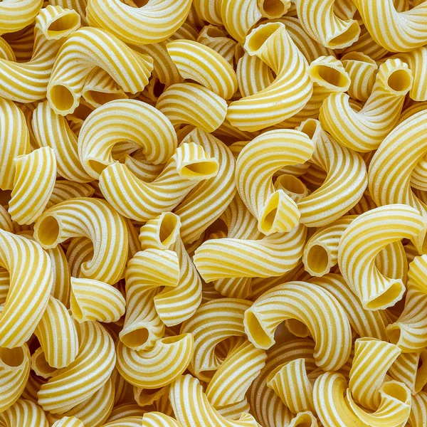 Macaroni rigati achtergrond met pasta. Een uitzicht vanaf de top, een close-up van een textuur. — Stockfoto