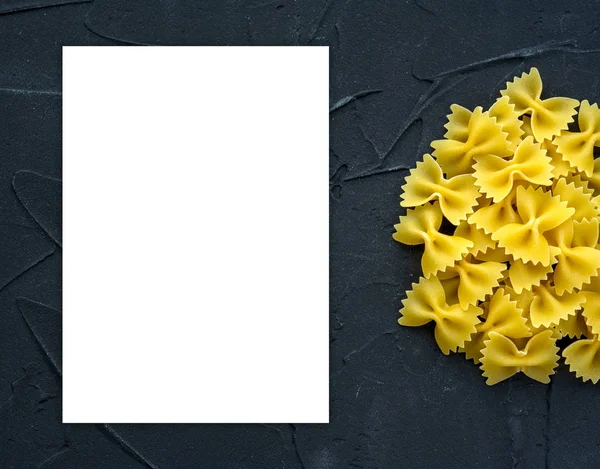 Farfalle Makkaroni Hintergrund mit Pasta auf schwarzem Hintergrund mit einer Seite. ein Blick von oben, eine Nahaufnahme einer Textur. weißer Raum für Text und Ideen. — Stockfoto