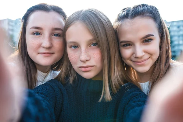 10代の女の子3人彼らは電話で写真を撮る、幸せな笑顔の遊びは楽しいです。オンラインアプリケーションインターネット、ソーシャルネットワーク。夏の都市で。学校の後の感情の緩和,オンラインビデオ通話. — ストック写真