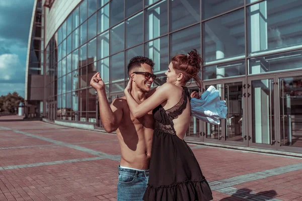 Young couple girl and man dancer happy play have fun laugh, dance glass windows background, summer city, hip hop style break dancer. Active youth lifestyle modern fashionable hipster couple street .