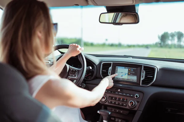 Lány rózsaszín autó vezetés autó kiválaszt egy alkalmazás érintőképernyős kijelző, bekapcsolja a navigációt, kiválasztja az útvonalat, parkol a városon kívül, beállítja az útvonalat, mielőtt elkezd mozogni a természetben. — Stock Fotó