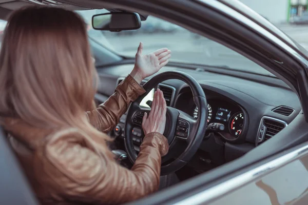 Ragazza che guida la macchina in cabina. Segnale di clacson incidente mano gesto, bip, conflitto, emozione stress aggressione malcontento. Incomprensione scandalo e incidente su strada. Guida a destra, guida a sinistra . — Foto Stock